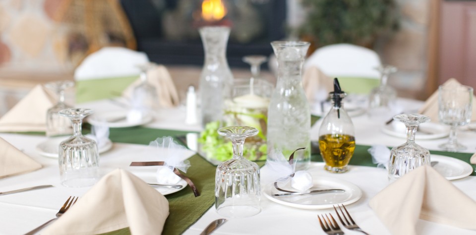 Place setting for a wedding with glasses, cloth napkins, silverware and party favors
