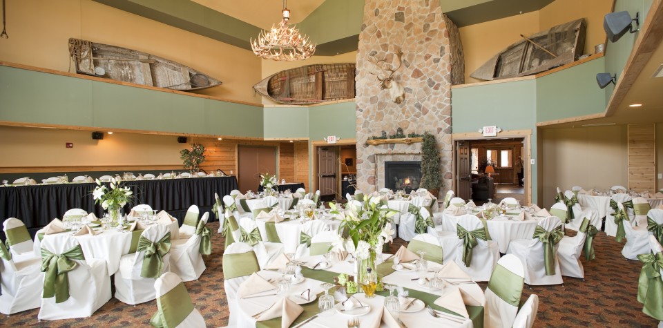 Reception setup with many round tables and one long rectangular table for the bridal party