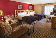 Double Queen Beds with two chairs, and a tv on a dresser
