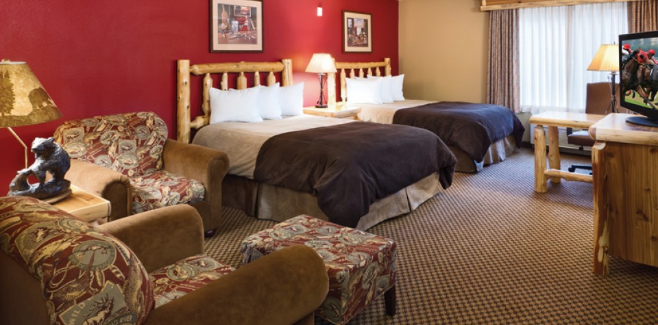 Double Queen Beds with two chairs, and a tv on a dresser