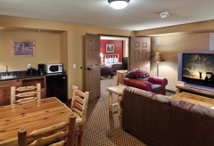 Dining/Kitchen with sink, mini fridge, and microwave and the living room with sofa, chair, and tv